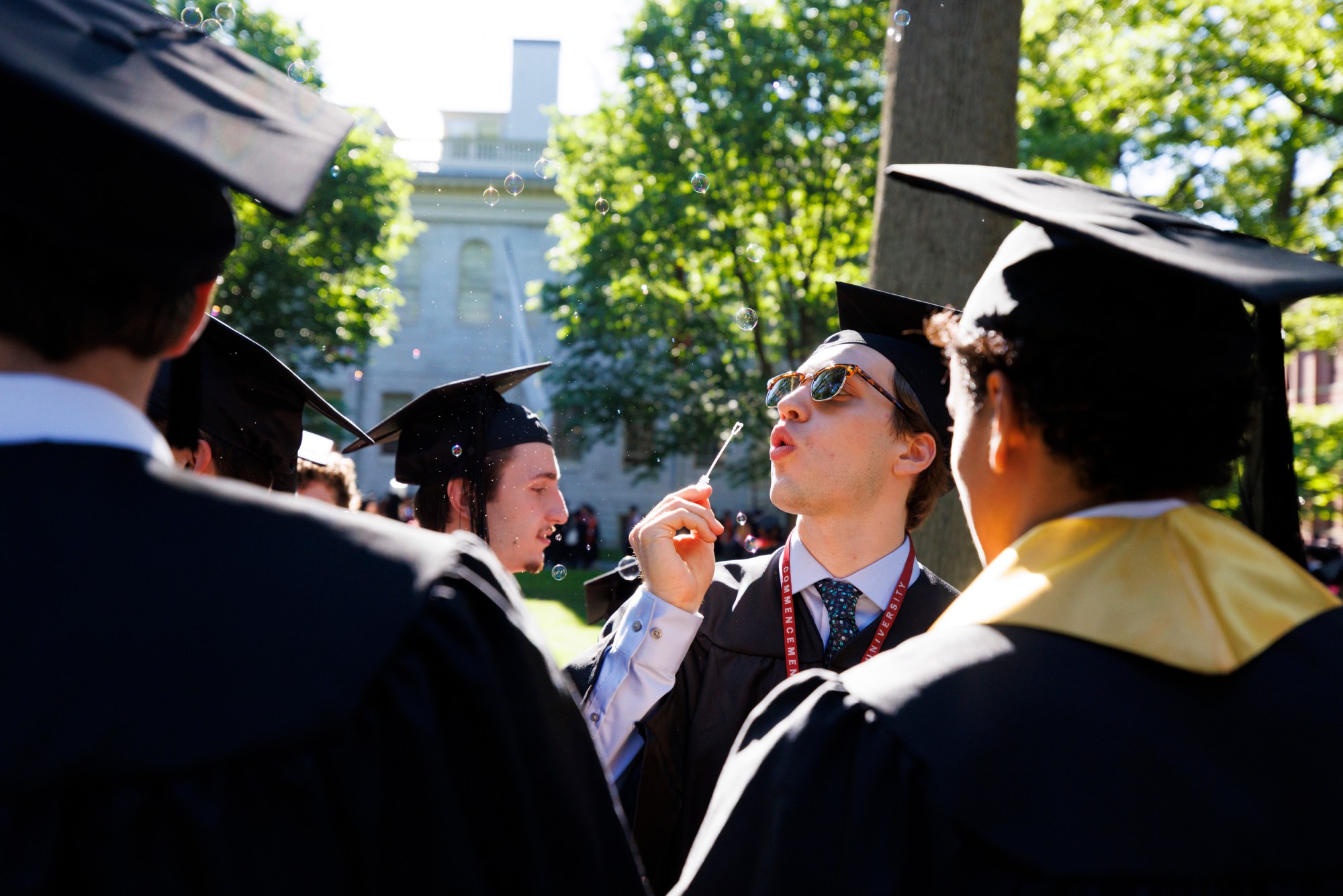 A graduate blows bubbles at Commencement.